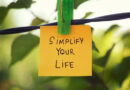 A post-it note hanging on a tree that says: Simplify Your Life.