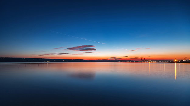 A sunrise over a very still lake.