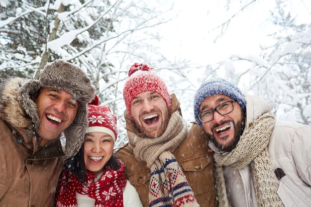 Four happy friends out in a winter forest.