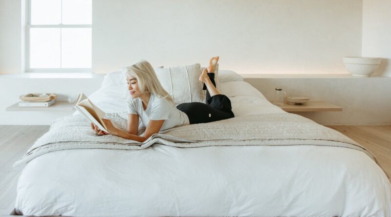 Woman reading feel-good book in bed.