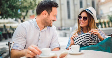 A happy couple sitting outside and having coffee.