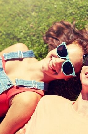 Smiling couple lying in the spring grass.