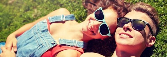 Smiling couple lying in the spring grass.