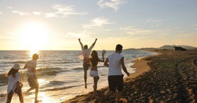 Friends running on the beach during a summer sunset.