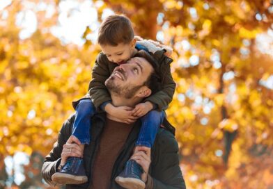 A smiling son riding on his father