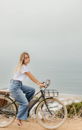 Woman biking by the ocean.