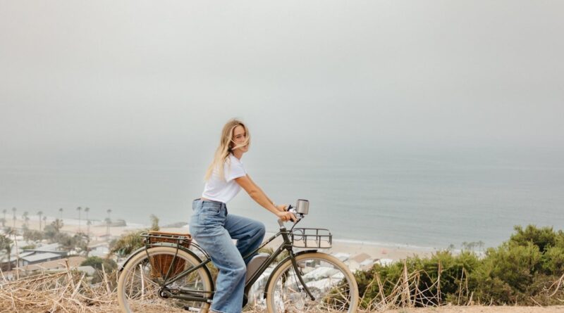 Woman biking by the ocean.